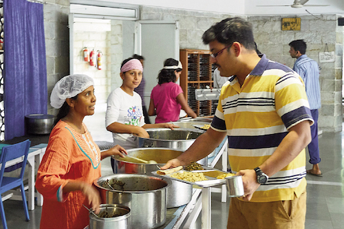 Serving food in Ashram cafeteria